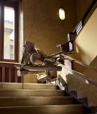 wood sculpture on stairs mike nelson