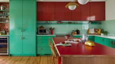 kitchen with green base units and red wall cabinets