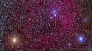 A smattering of stars numbers in the thousands across the image, a deep purple background fades to black inconsistently throughout. A small number of exceptionally bright stars shine evident in the bottom corners and just above right center.
