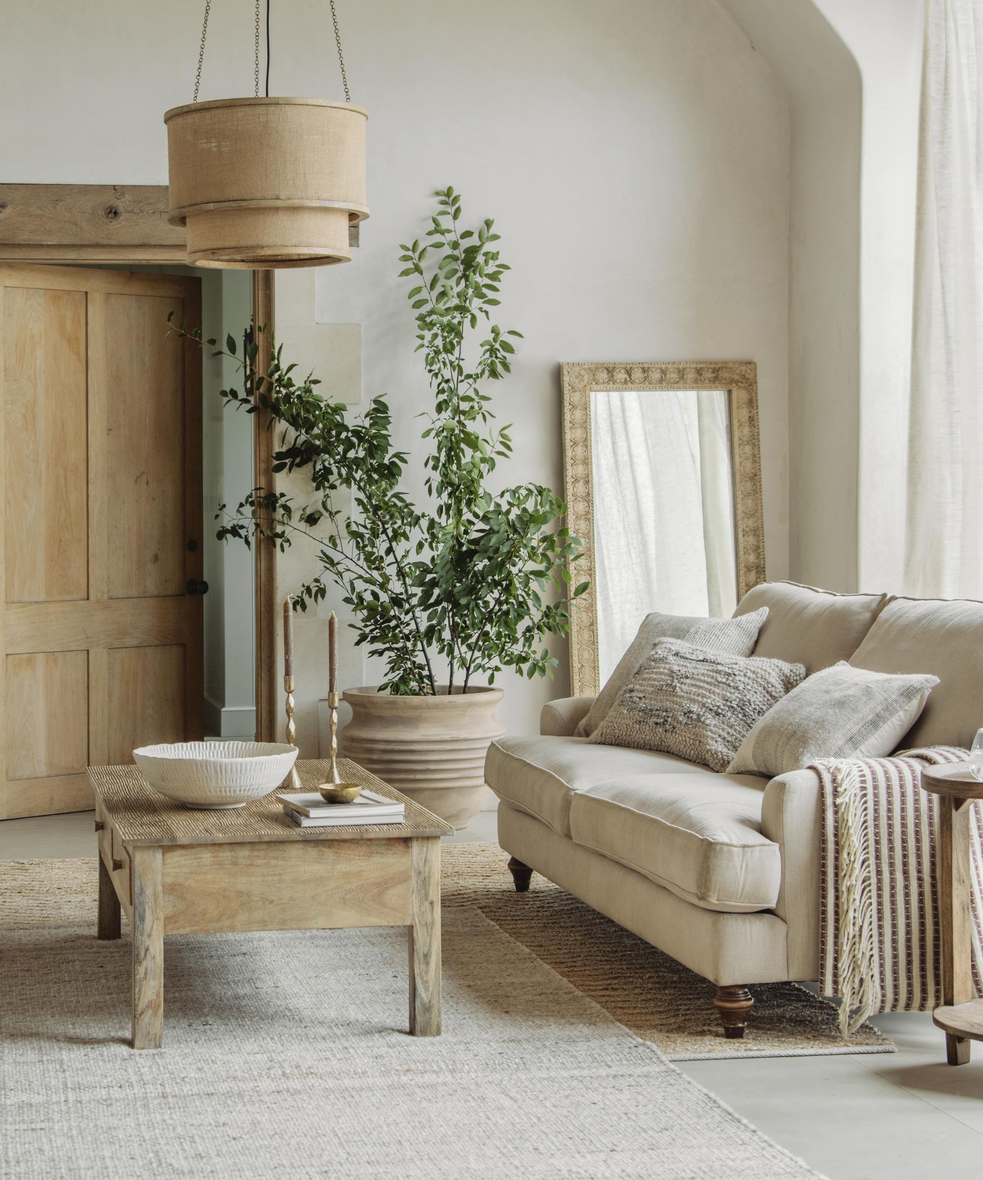 A white living room with white chairs and wooden furniture