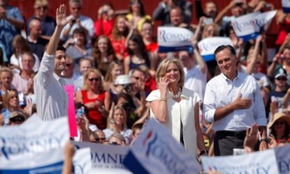 Mitt and Ann Romney stand onstage at a campaign stop in Michigan, where the Republican received cheers from the crowd after cracking a birther joke.