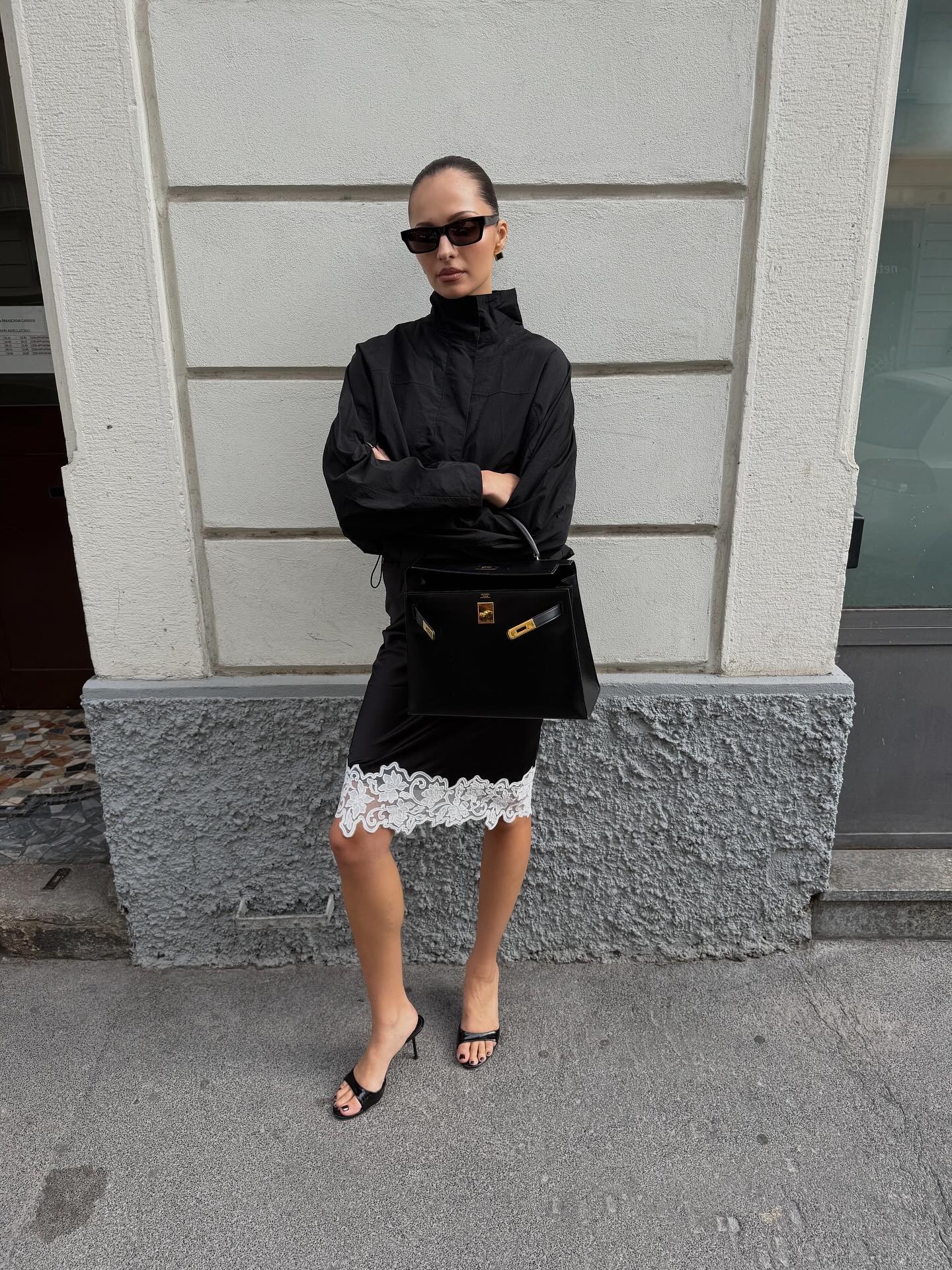 Woman in sporty jacket and lace-trim skirt