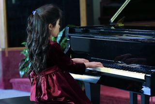 Child playing piano recital.