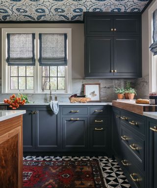 Dark blue kitchen with wallpapered ceiling