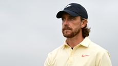 Tommy Fleetwood at The Open wearing a yellow polo and black cap