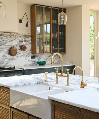 devol kitchens island with marble countertop and sink