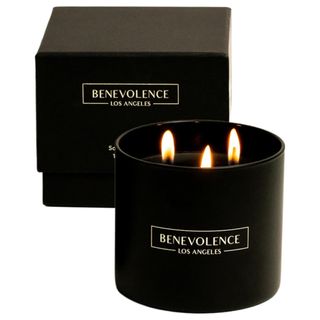 A black three wick candle with black cardboard box