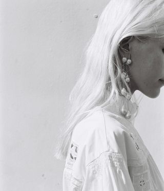 Woman wearing long hanging pearl earrings