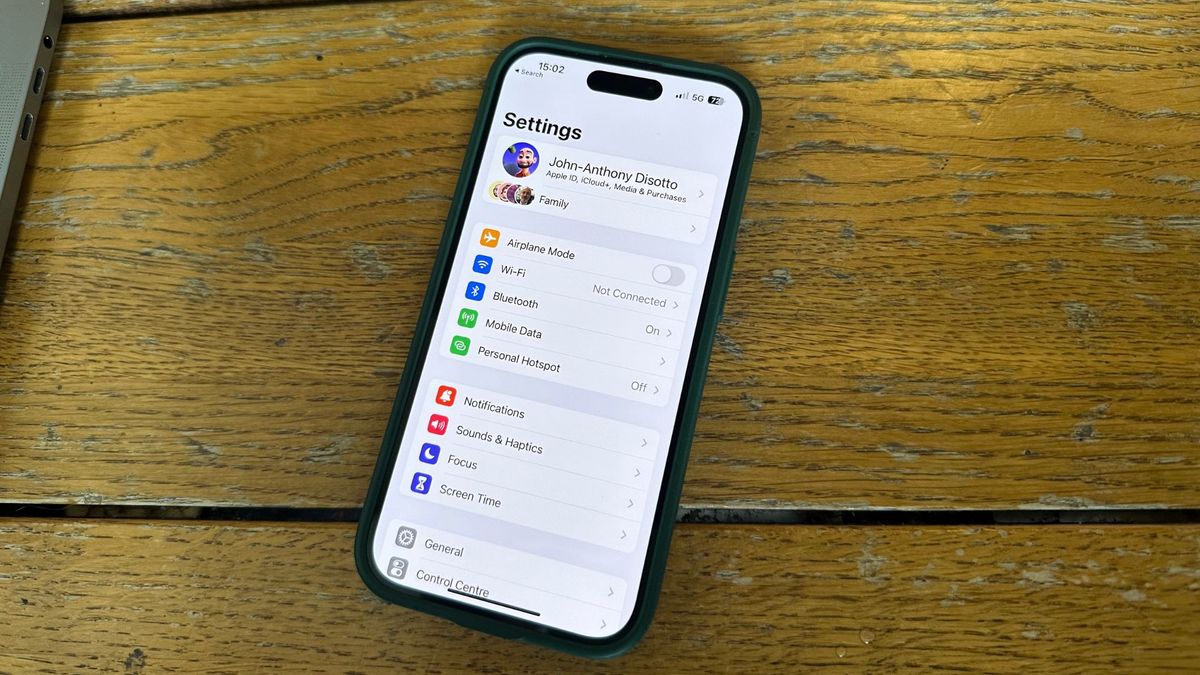 An iPhone on a desk showing the Settings app to help you reset your Apple ID password