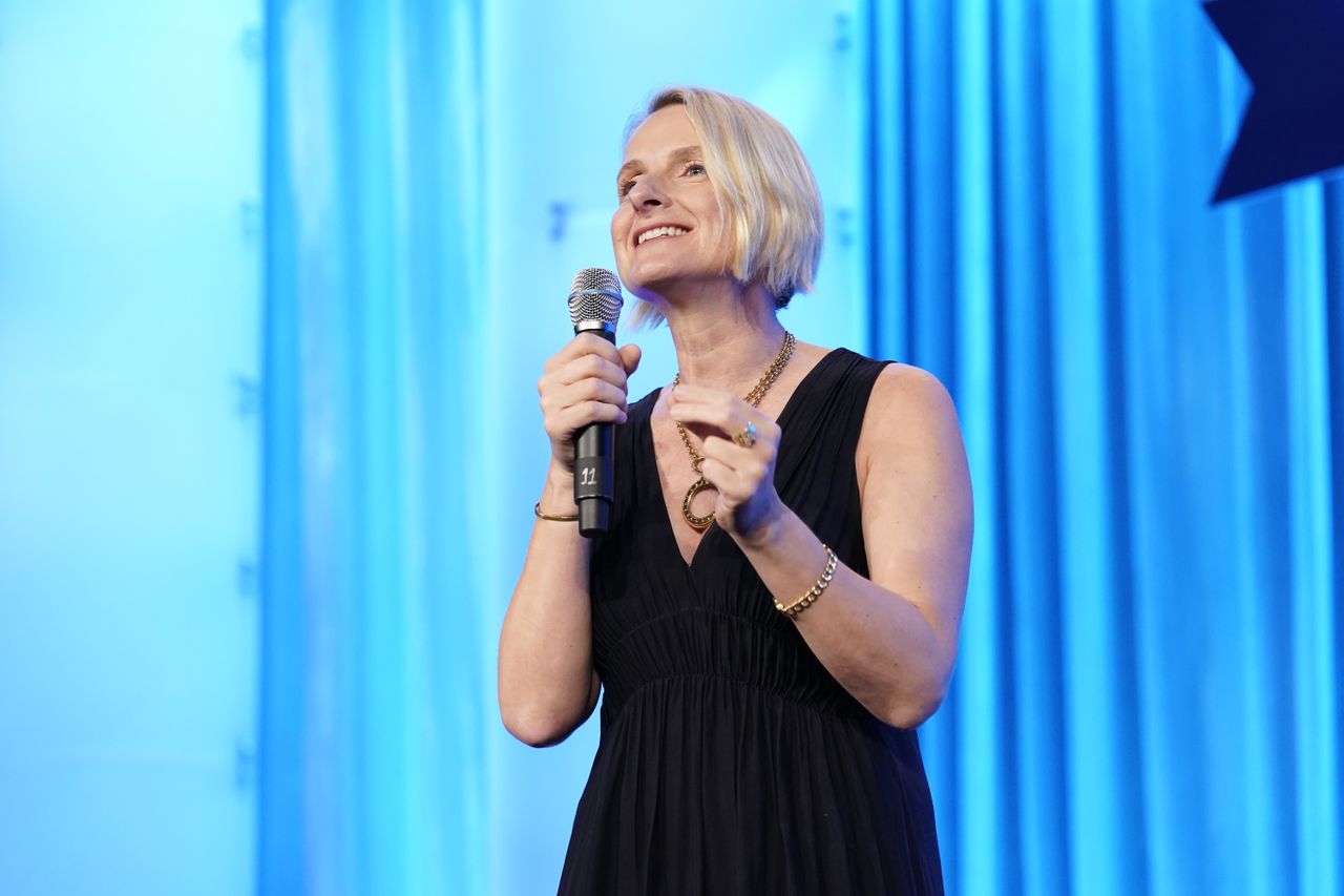 Elizabeth Gilbert holding a microphone 