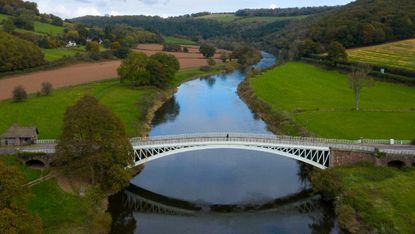 A person crosses from England to Wales over Bigsweir Bridge