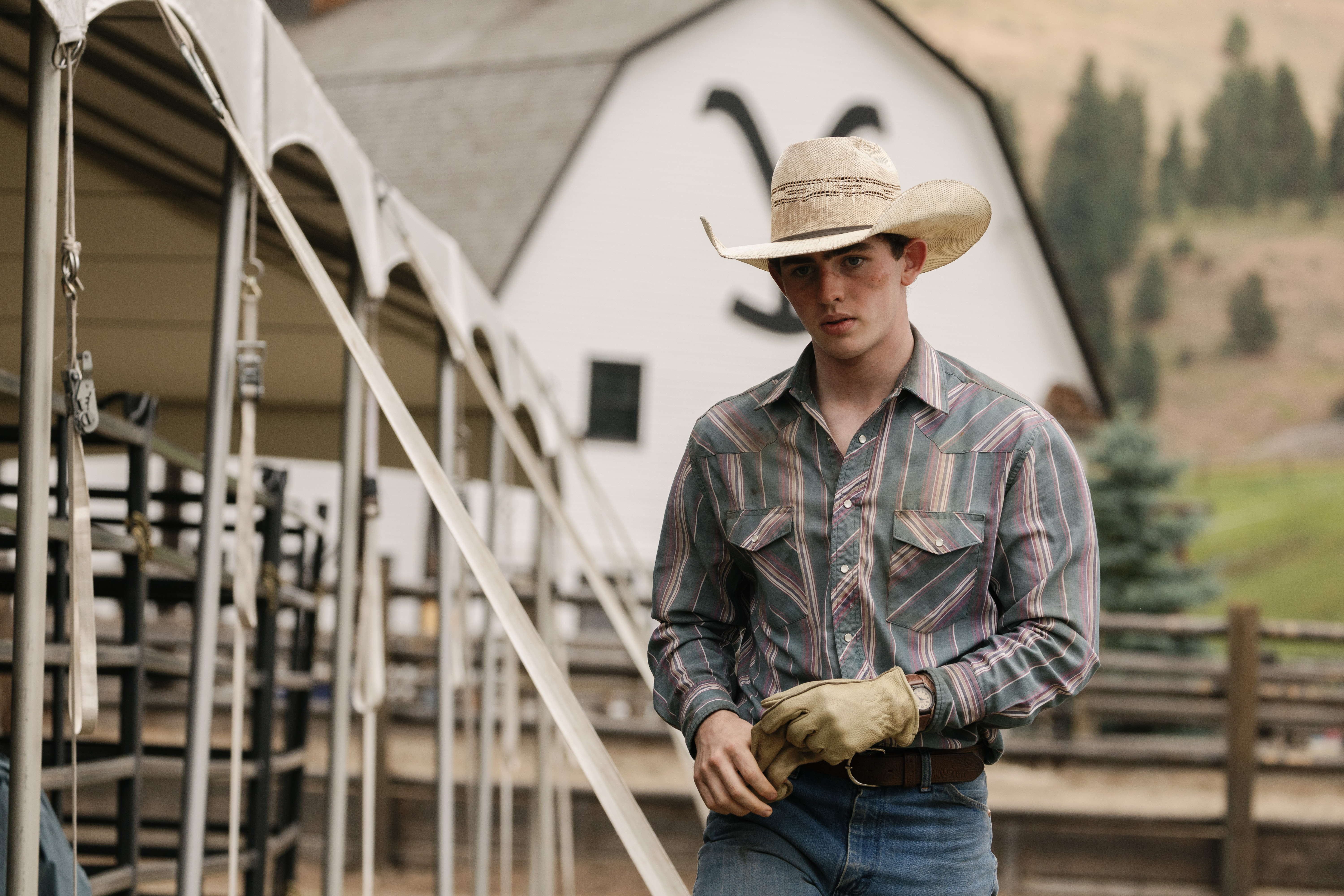 Finn Little who plays Carter walks across the ranch.