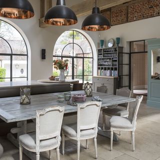 kitchen room with semi arched glass windows and table with chairs