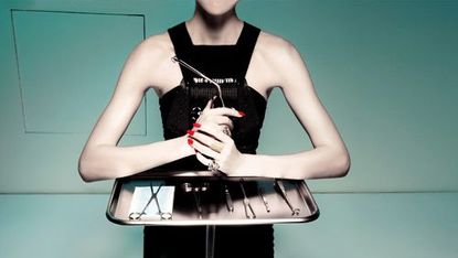 model with tray of plastic surgery tools