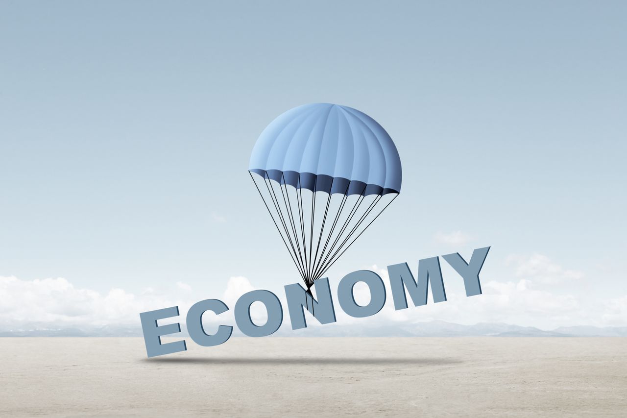 soft landing concept shown word economy tied to a parachute slowly falling to the ground