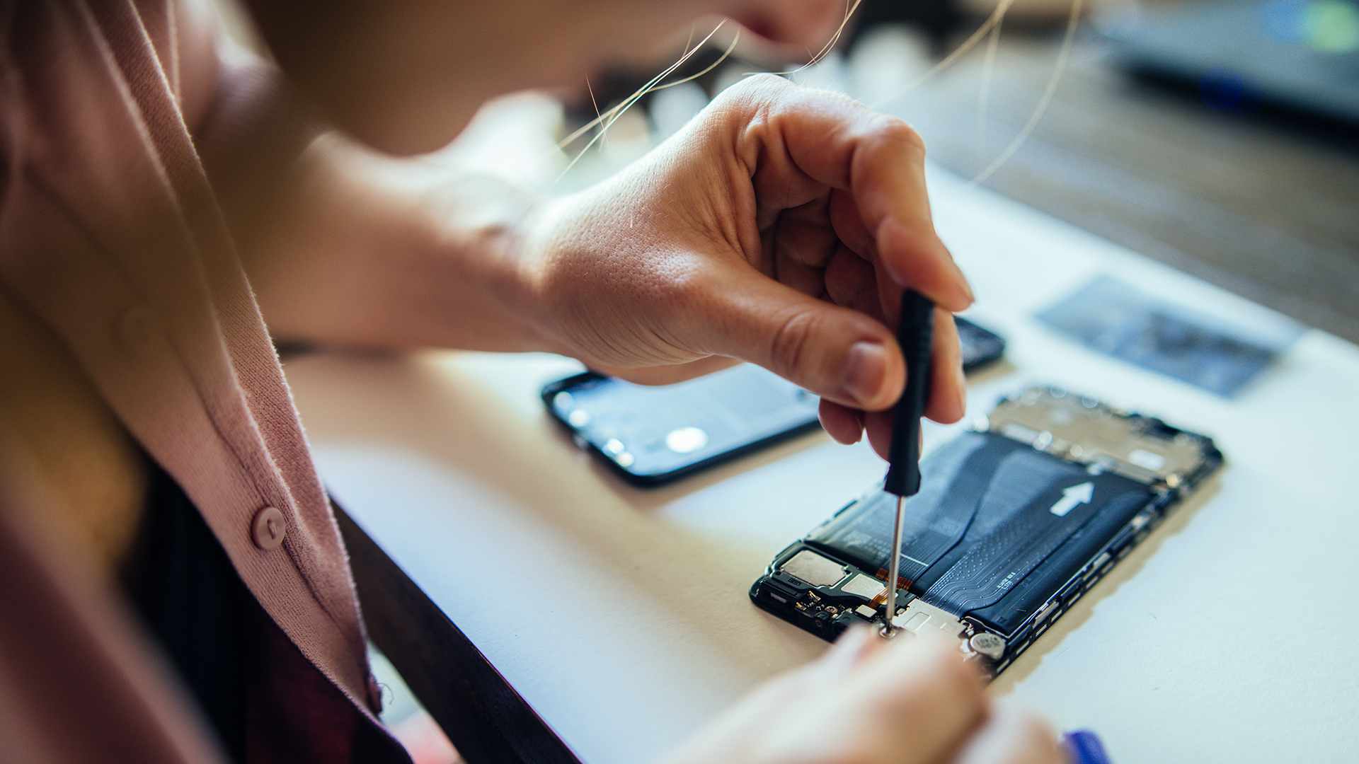 Woman fixing a damaged part in a phone