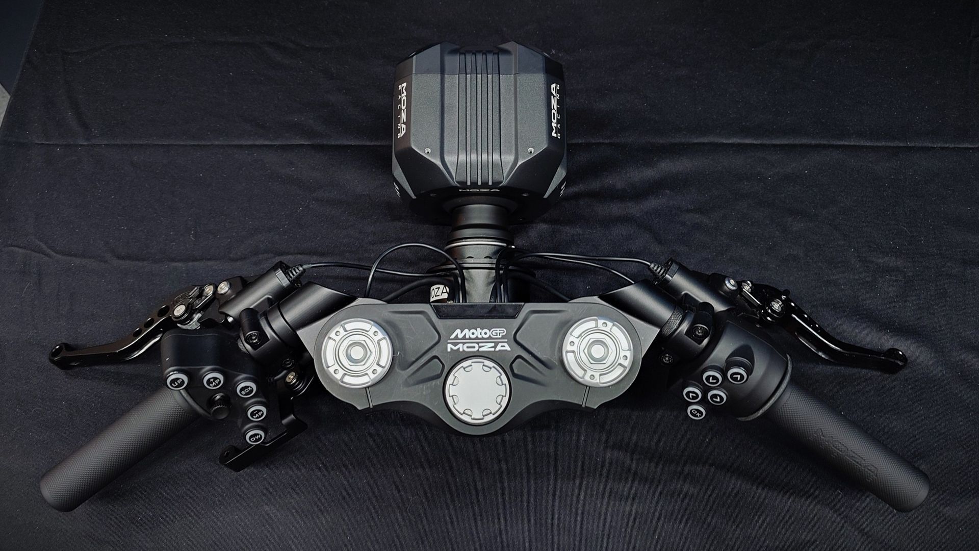 A photo of the Moza Racing MotoGP handlebars connected to a Moza wheelbase on a black backdrop.