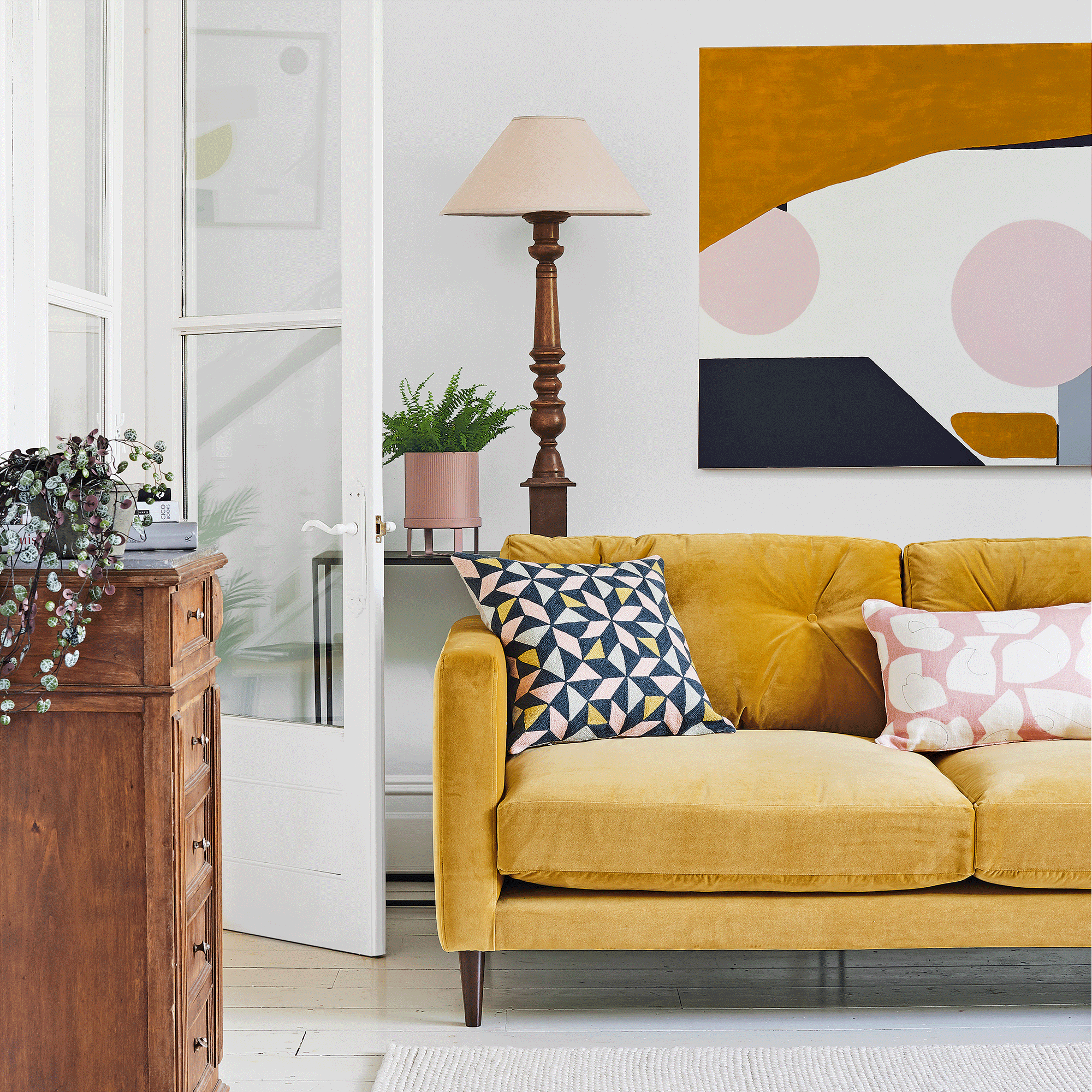 Yellow sofa in white living room with wall art