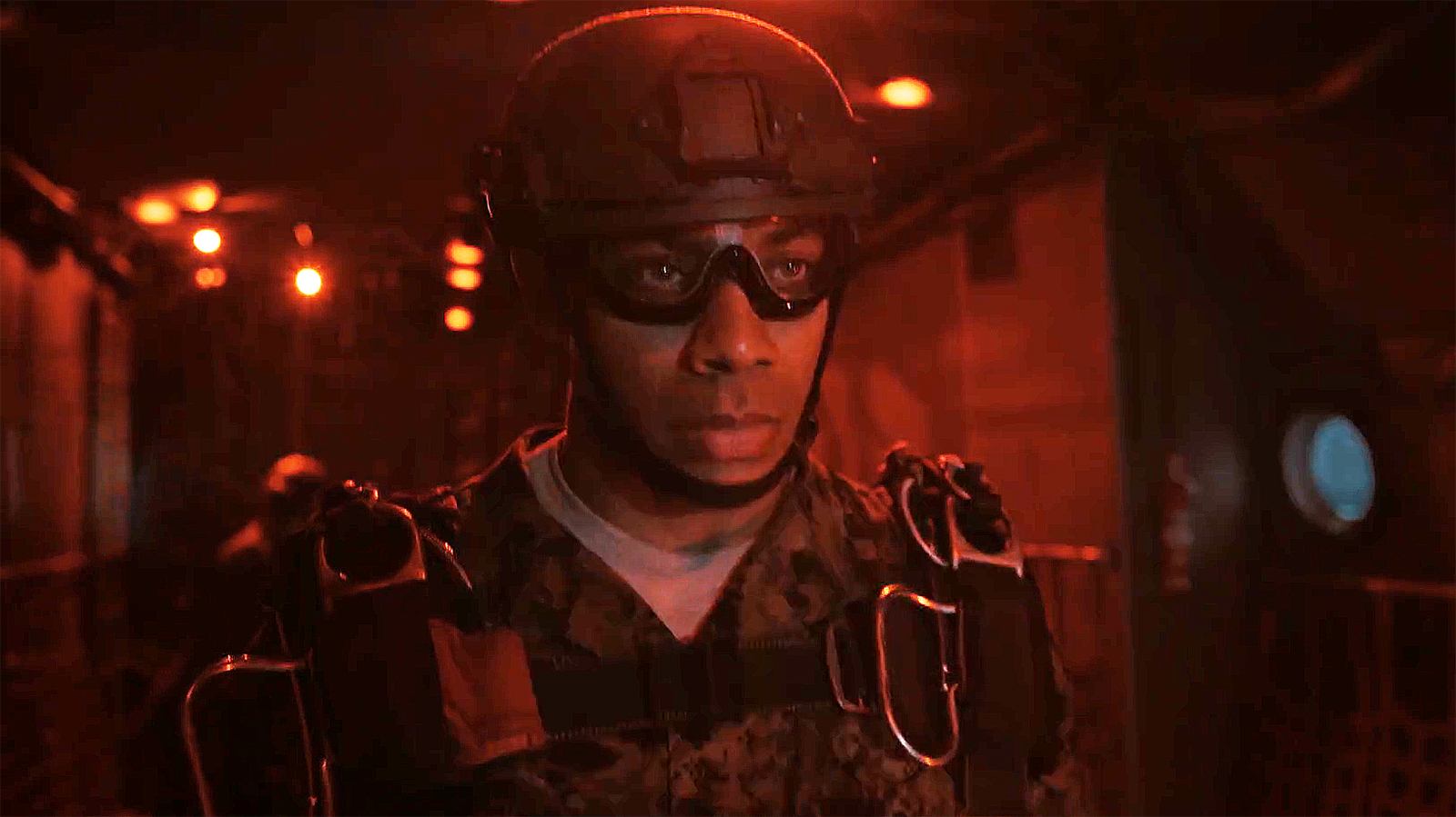 Aaron Pierre's John Stewart wearing his marine gear as he stands under a red light in a military plane in Lanterns episode 3
