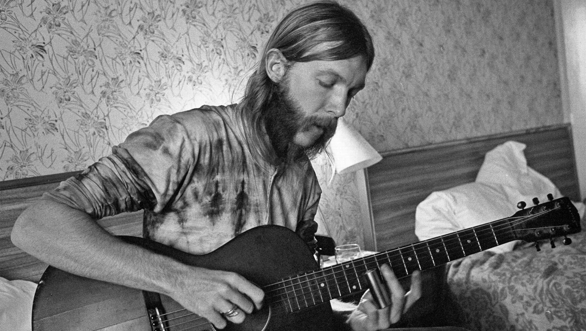 Duane Allman uses a steel slide on an acoustic guitar in his hotel room before the Allman Brothers' performance at the Sitar on October 17, 1970 in Spartanburg, South Carolina.