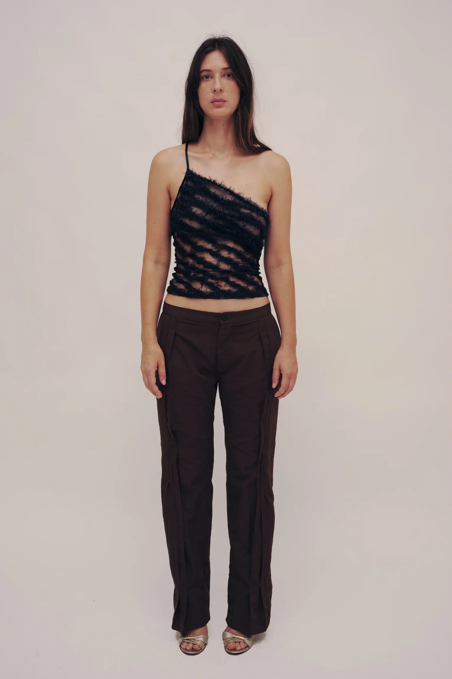 Gauntlett Cheng model wearing brown asymmetrical top and ribbed flared skirt