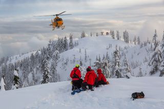 Helicopter attending winter rescue on mountain