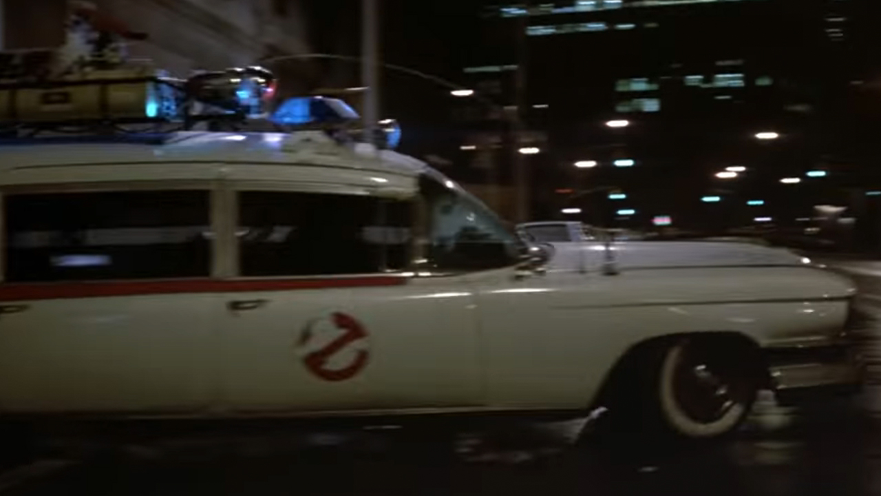 The Ecto-1 coming out of the garage of the Ghostbusters headquarters