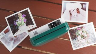 Kodak Smile Classic on a table with instant prints