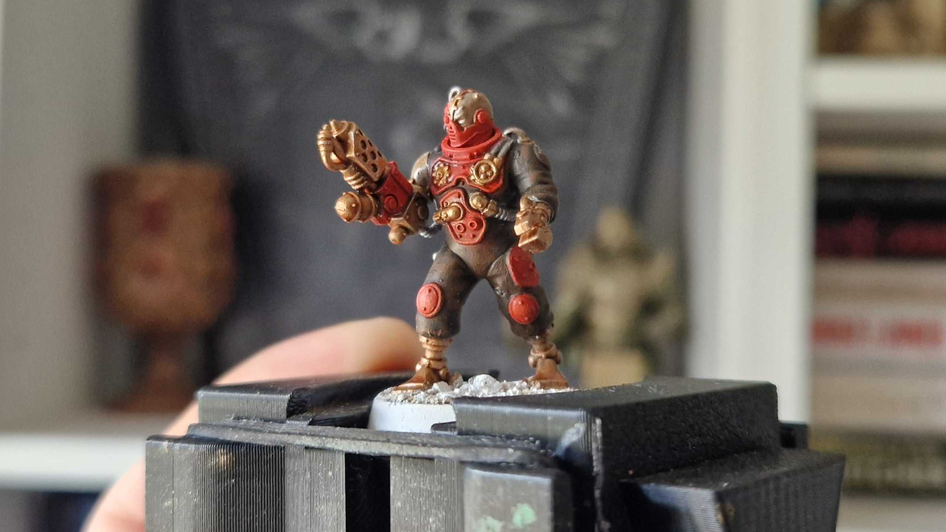 A Battleclade servitor model being held up on a painting handle