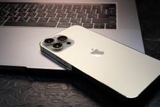 Apple mobile phone sitting on a laptop