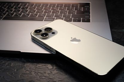 Apple mobile phone sitting on a laptop