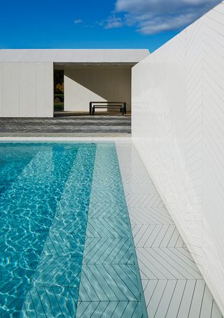 Laser-cut tiles are laid in a chevron pattern that references traditional French parquet