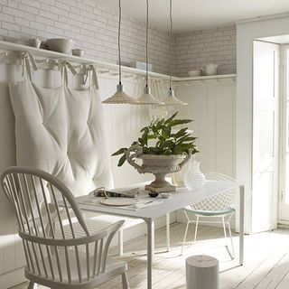 dining area with white wall and wooden floor and white dining table and chair