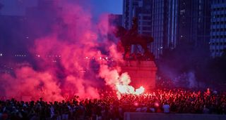Liverpool fans let off flares outside the Liver Building