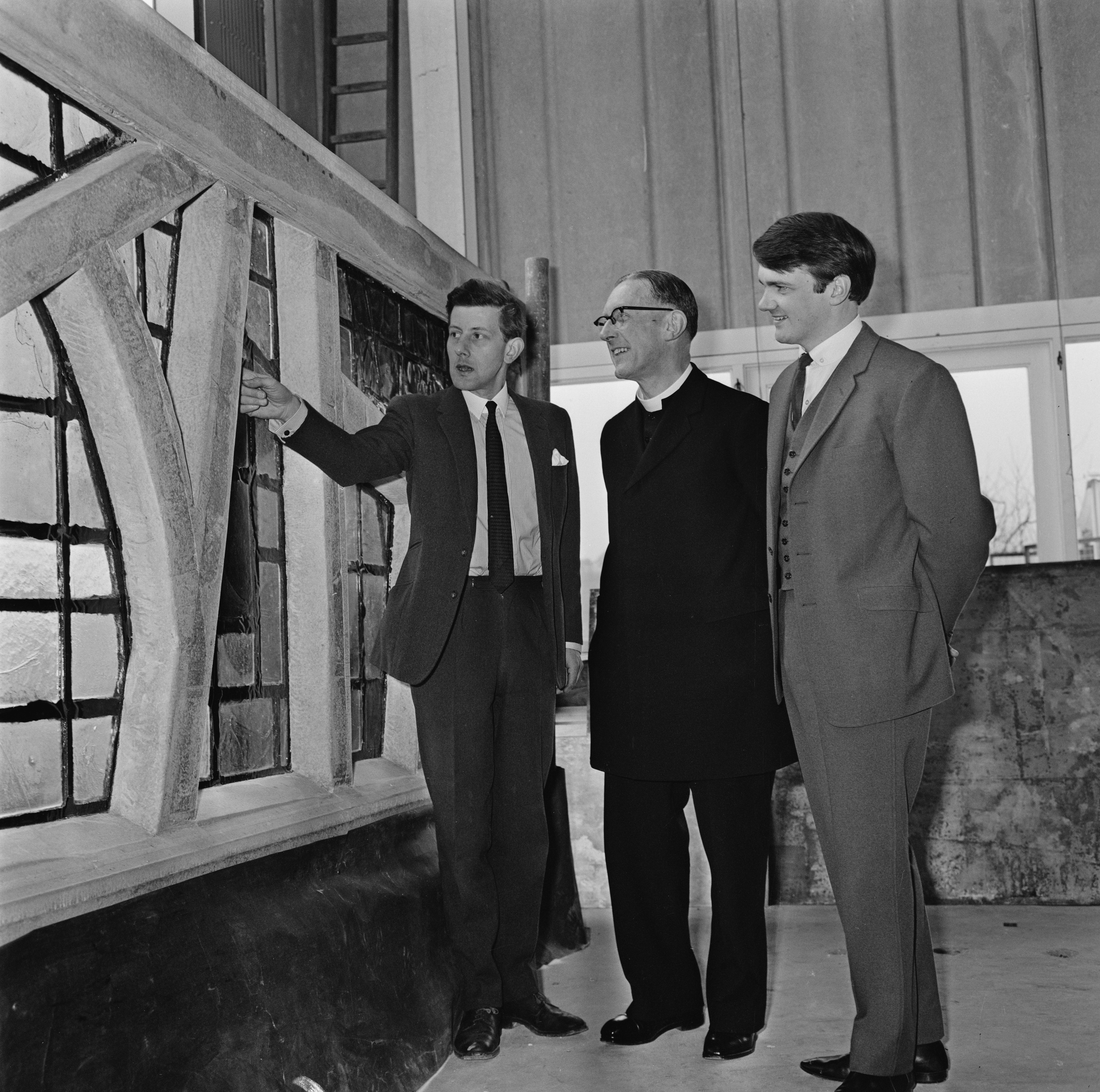The Archbishop of Liverpool George Beck (centre) with his assistant David Kirby (right) visiting the studio of stained-glass artist Patrick Reyntiens (left) in Loudwater, Buckinghamshire, in 1965, to view the stained glass window panels, which were being made for the Lantern Tower of Liverpool Metropolitan Cathedral.