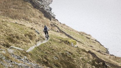 Best mountain bike: Person riding a Voodoo Bizango Pro mountain bike on a coastal trail