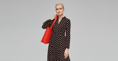 Woman wearing a Hobbs red bag and navy polka dot dress