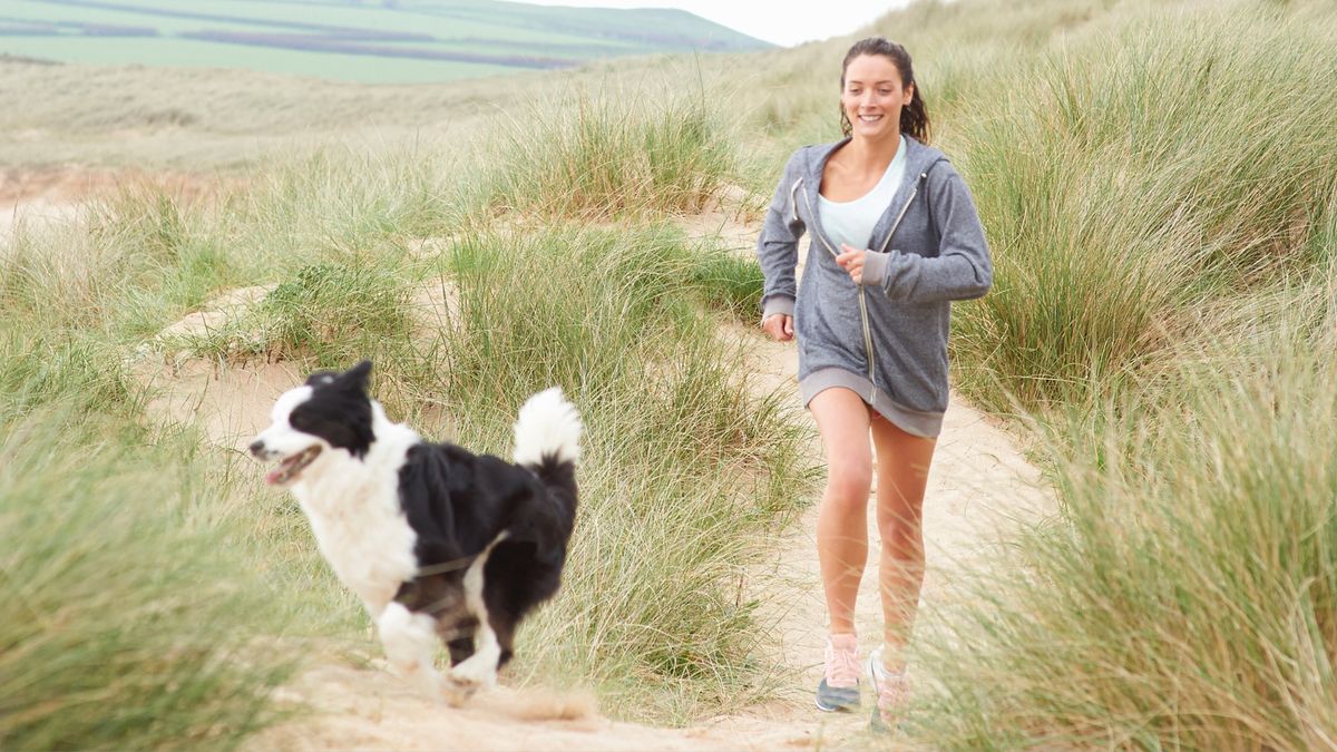 Woman walking her dog in the sand dunes