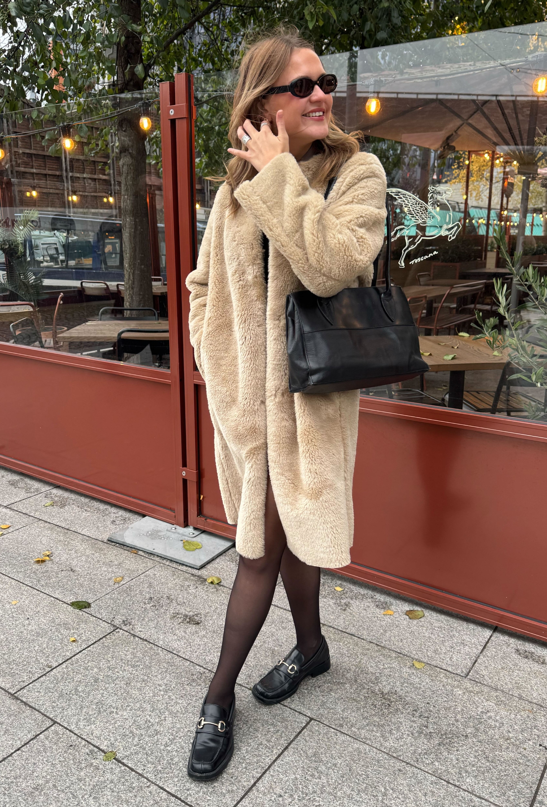 An editor from Who What Wear UK modelling a teddy coat