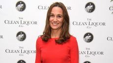 Pippa Middleton wearing red trousers and top with navy accessories