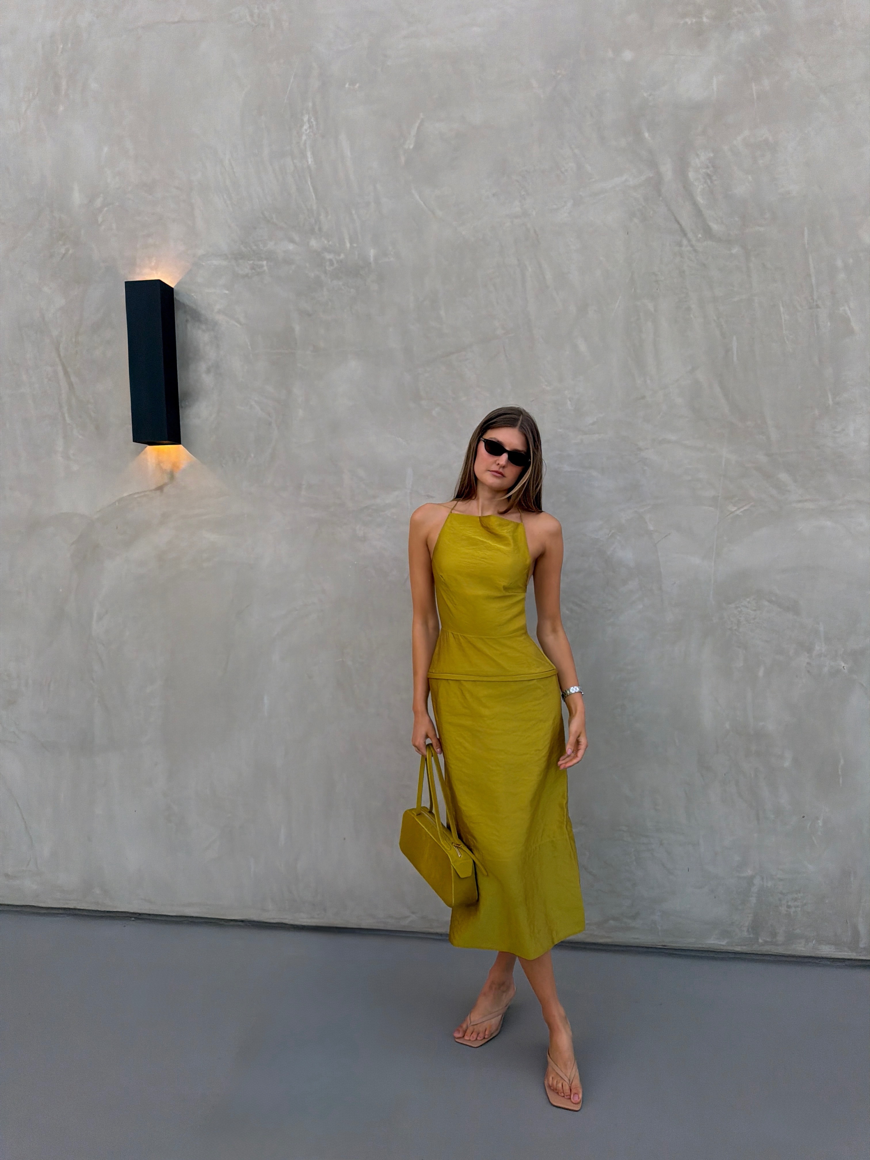Woman in a chartreuse top and skirt.