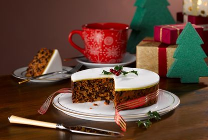 Gluten-free Christmas cake topped with marzipan and icing and decorated with a festive ribbon