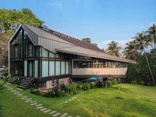 The house is set on a sloping site in a tropical garden