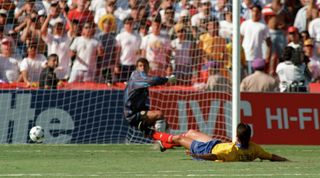 Colombian defender Andres Escobar lies on the ground after scoring an own goal past goalkeeper Oscar Cordoba while trying to stop a shot from US forward John Harkes during the World Cup first round soccer match between the United States and Colombia 22 June 1994 in Los Angeles. The United States beat Colombia 2-1. AFP PHOTO/ROMEO GACAD (Photo credit should read ROMEO GACAD/AFP via Getty Images)