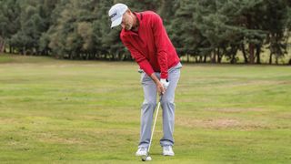 Tilting the spine at address when setting up to play a wedge shot in golf