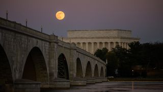 a red dot next to a full moon