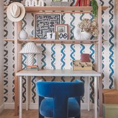 Home office with light oak desk and squiggle wallpaper.