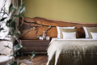 A bedroom with a long headboard in live edge wood