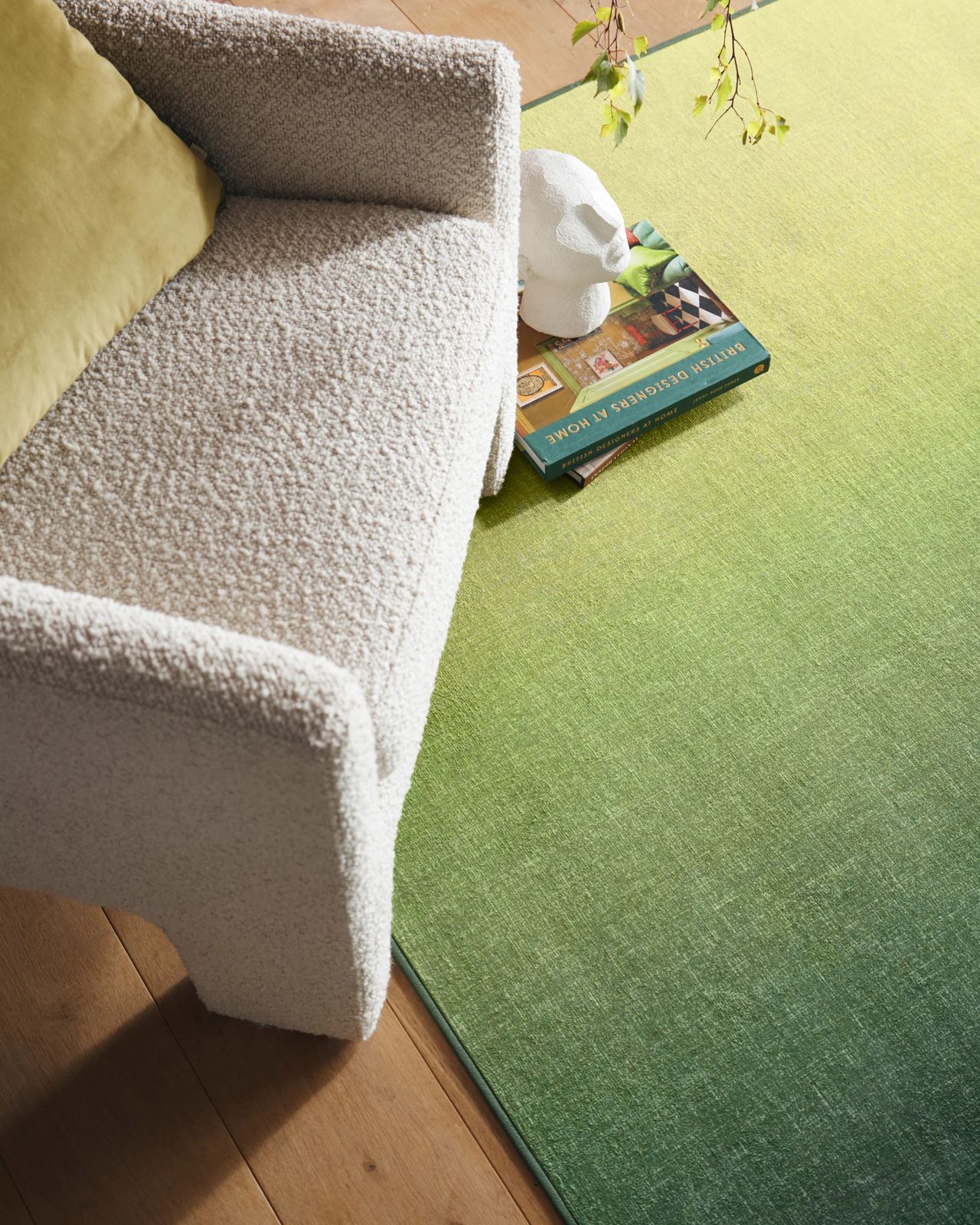 Hug Rug x Livingetc rug collaboration with green ombre rug with boucle armchair and stack of books on floor