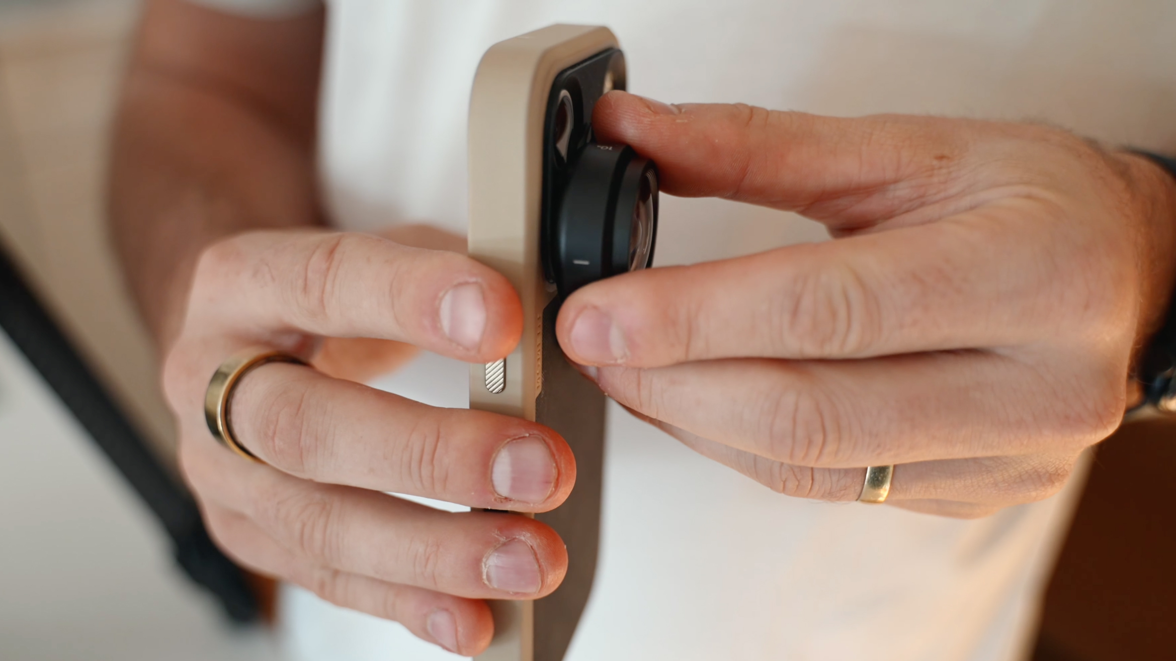 A person twists the new Moment Macro 10X II lens onto a phone